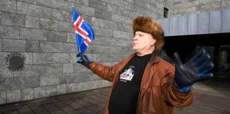 A protestor waves an Icelandic flag outside the Central Bank of Iceland during a demonstration in Reykjavik, Oct. 10, 2008 (AP Photo/Arni Torfason).